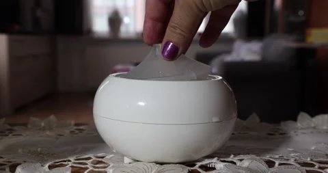 Hands putting the plastic caps on an aroma oil diffuser humidifier inside a home Video stock 211167044