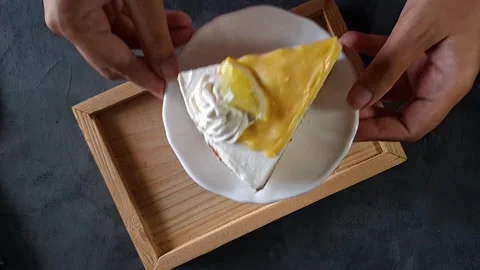 Hands putting plate with slice of lemon blueberry cake on wooden tray Video stock 336591256