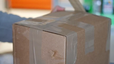 Hands putting self-adhesive tape on box Stock Footage 101814327