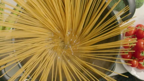 Hands Putting Spaghetti into Pot with Boiling Water Stock Footage 249838704