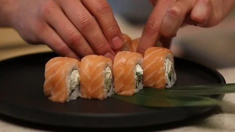 Hands putting sushi. Master sushi rolls puts sushi. Stock Footage 126769335