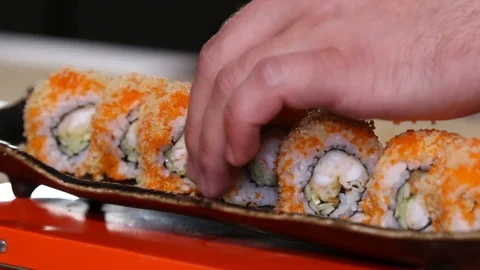 Hands putting sushi. Master sushi rolls puts sushi. Video stock 129832058