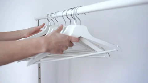 Hands Putting Together Empty Hangers Tacking off from Bar Stock Footage 148126838