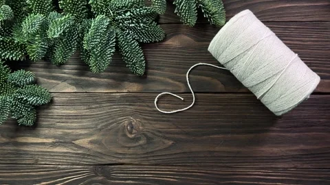 Hands putting twisted cotton, jute ropes and scissors on wooden table decorated Stock Footage 259033664