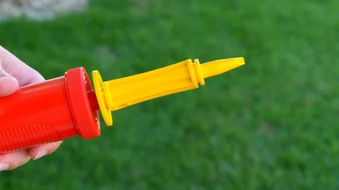 Hands putting a Violet ballon in a pump and inflating it. Close up shot. Stock Footage 123730441