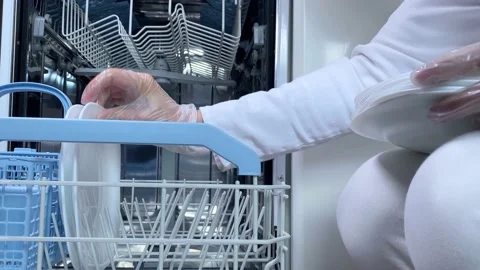 Hands putting white plates in dishwasher. Stock Footage 168183680