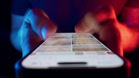 Hands Rapidly Scroll on Bright Smartphone Display with Shutter Drag Blur in Stock Footage 319849862