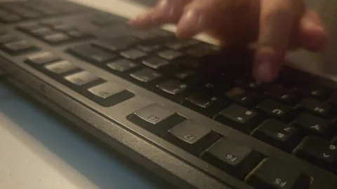 Hands rapidly typing on a black computer keyboard in low light 스톡 동영상 346547114