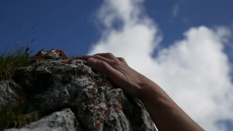 Hands reaching and grabbing a rock handhold  during climbing, closeup. Stock Footage
