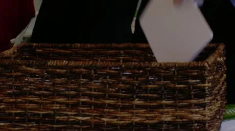 Hands Reaching into Basket for Programs Stock Footage