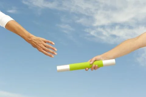 Hands reaching baton for teamwork Foto stock