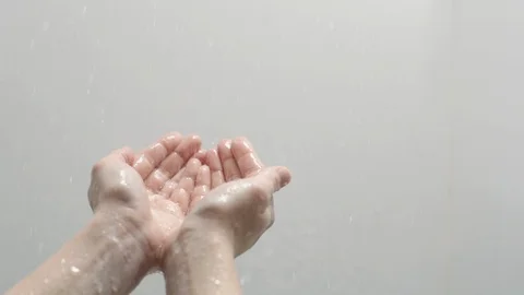 Hands reaching out to touch rain on white background Stock Footage 88050793