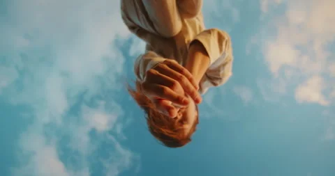 Hands reaching toward the sky framed by rocky edge during dance performance Stock Footage 319877497
