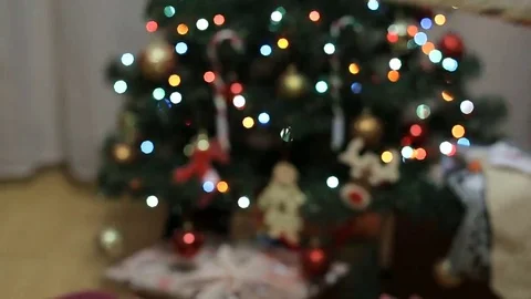 Hands Receiving Present In Front Of Glittering Christmas Tree Stock Footage 69319604