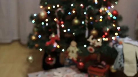 Hands Receiving Present In Front Of Glittering Christmas Tree Stock Footage 69325114