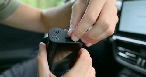 Hands remove a micro SD card from a dash camera device in car interior Stock Footage 318954241