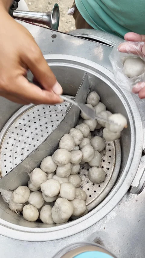 Hands remove steamed dumplings from a steamer Stock Footage 346685082