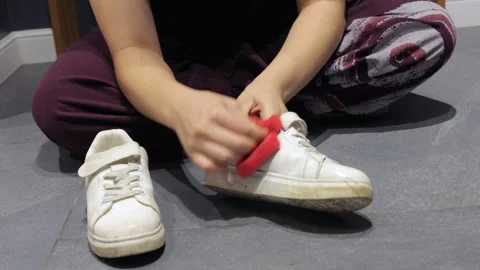 Hands removing dirt from white sneaker 스톡 동영상 337955385