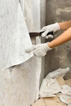 Hands removing old wallpaper from wall Stock Photos