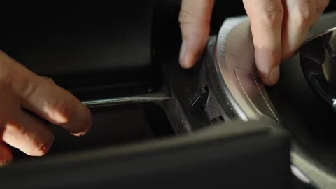Hands removing silver trim panel from car console with tool Stock Footage 337567969
