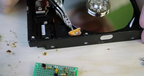 Hands repair hard drive components. Precision tools work on internal mechanisms Stock Footage 348486899