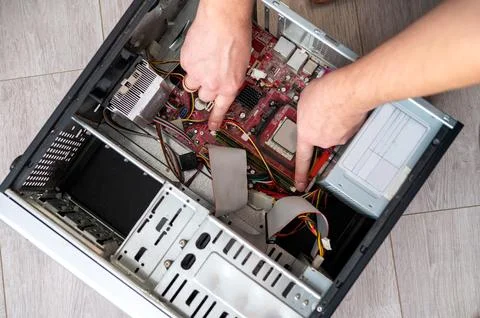 Hands repairing computer hardware inside an open desktop pc case Stock Photos