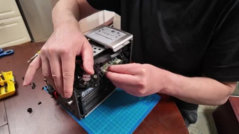 Hands repairing an electronic device with exposed components and a cooling fa Stock Footage 304331151