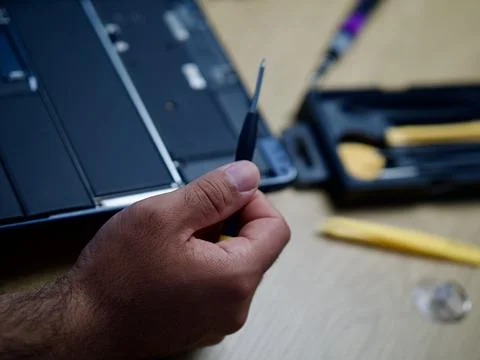 Hands Repairing an Opened Laptop Computer With Precision Tools Stock Photos