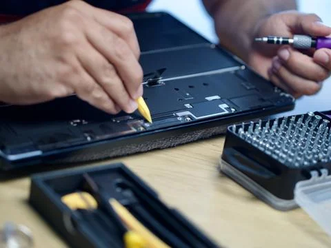 Hands Repairing an Opened Laptop Computer With Precision Tools Stock Photos