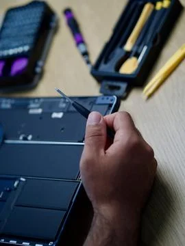 Hands Repairing an Opened Laptop Computer With Precision Tools Stock Photos