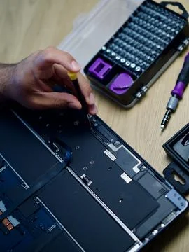 Hands Repairing an Opened Laptop Computer With Precision Tools Stock Photos
