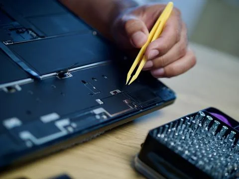 Hands Repairing an Opened Laptop Computer With Precision Tools Stock Photos