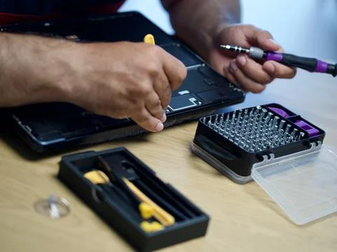 Hands Repairing an Opened Laptop Computer With Precision Tools Stock Photos