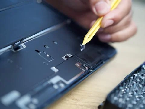 Hands Repairing an Opened Laptop Computer With Precision Tools Stock Photos
