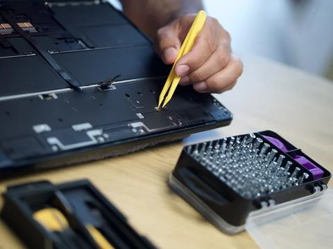 Hands Repairing an Opened Laptop Computer With Precision Tools Stock Photos