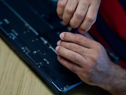 Hands Repairing an Opened Laptop Computer With Precision Tools Stock Photos