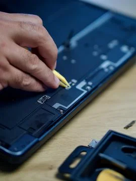 Hands Repairing an Opened Laptop Computer With Precision Tools Stock Photos