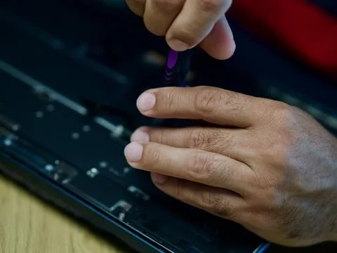 Hands Repairing an Opened Laptop Computer With Precision Tools Stock Photos