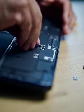 Hands Repairing an Opened Laptop Computer With Precision Tools Stock Photos
