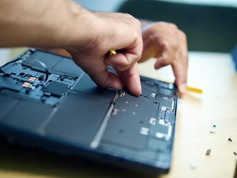 Hands Repairing an Opened Laptop Computer With Precision Tools Stock Photos