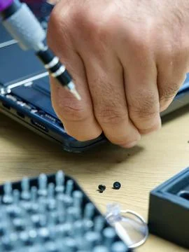 Hands Repairing an Opened Laptop Computer With Precision Tools Stock Photos