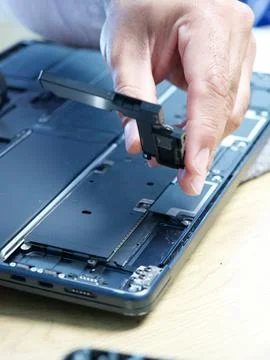 Hands Repairing an Opened Laptop Computer With Precision Tools Stock Photos