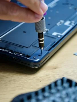 Hands Repairing an Opened Laptop Computer With Precision Tools Stock Photos