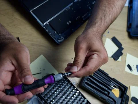 Hands Repairing an Opened Laptop Computer With Precision Tools Stock Photos