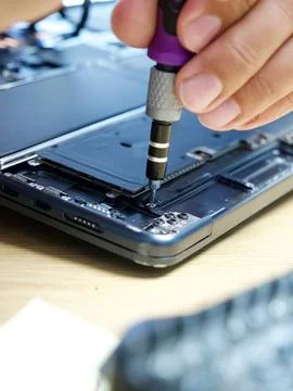 Hands Repairing an Opened Laptop Computer With Precision Tools Stock Photos