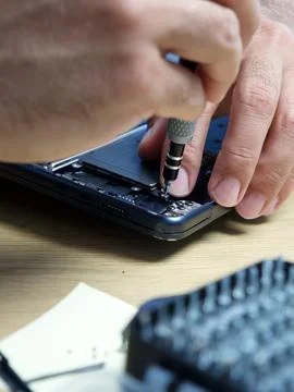 Hands Repairing an Opened Laptop Computer With Precision Tools Stock Photos
