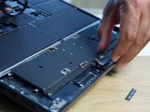 Hands Repairing an Opened Laptop Computer With Precision Tools Stock Photos