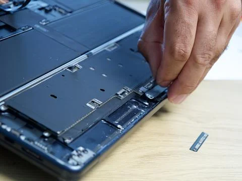Hands Repairing an Opened Laptop Computer With Precision Tools Stock Photos