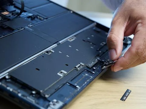 Hands Repairing an Opened Laptop Computer With Precision Tools Stock Photos