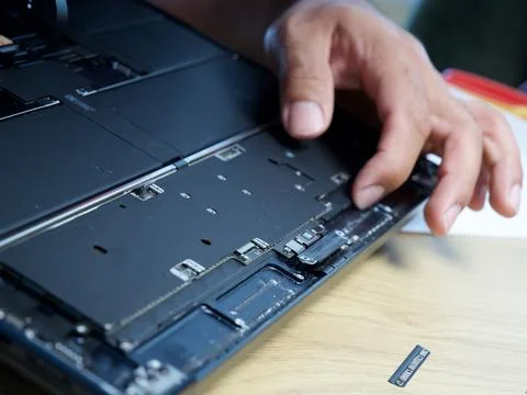 Hands Repairing an Opened Laptop Computer With Precision Tools Stock Photos